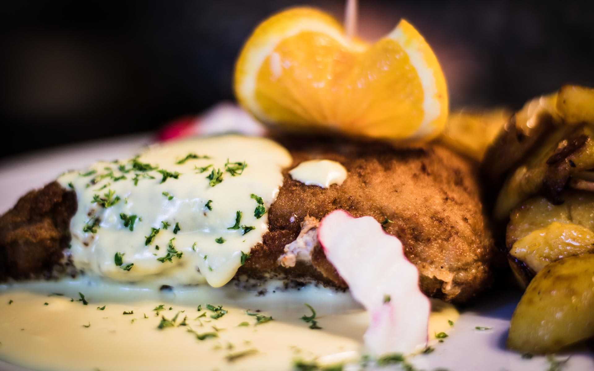 Detailaufnahme eines Schnitzels mit Bratkartoffeln und Soße. Ein Beispiel für die regionale Küche im Restaurant des Hotel Hennies in Isernhagen / Hannover.