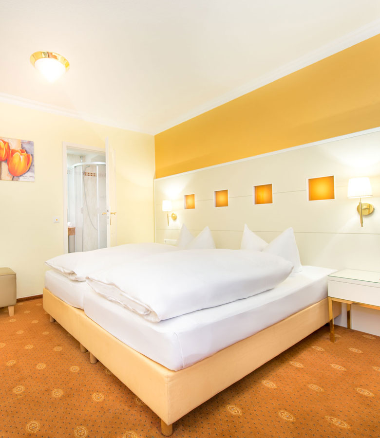 Beispiel für ein modern eingerichtetes Doppelzimmer im Hotel Hennies mit separatem Badezimmer.